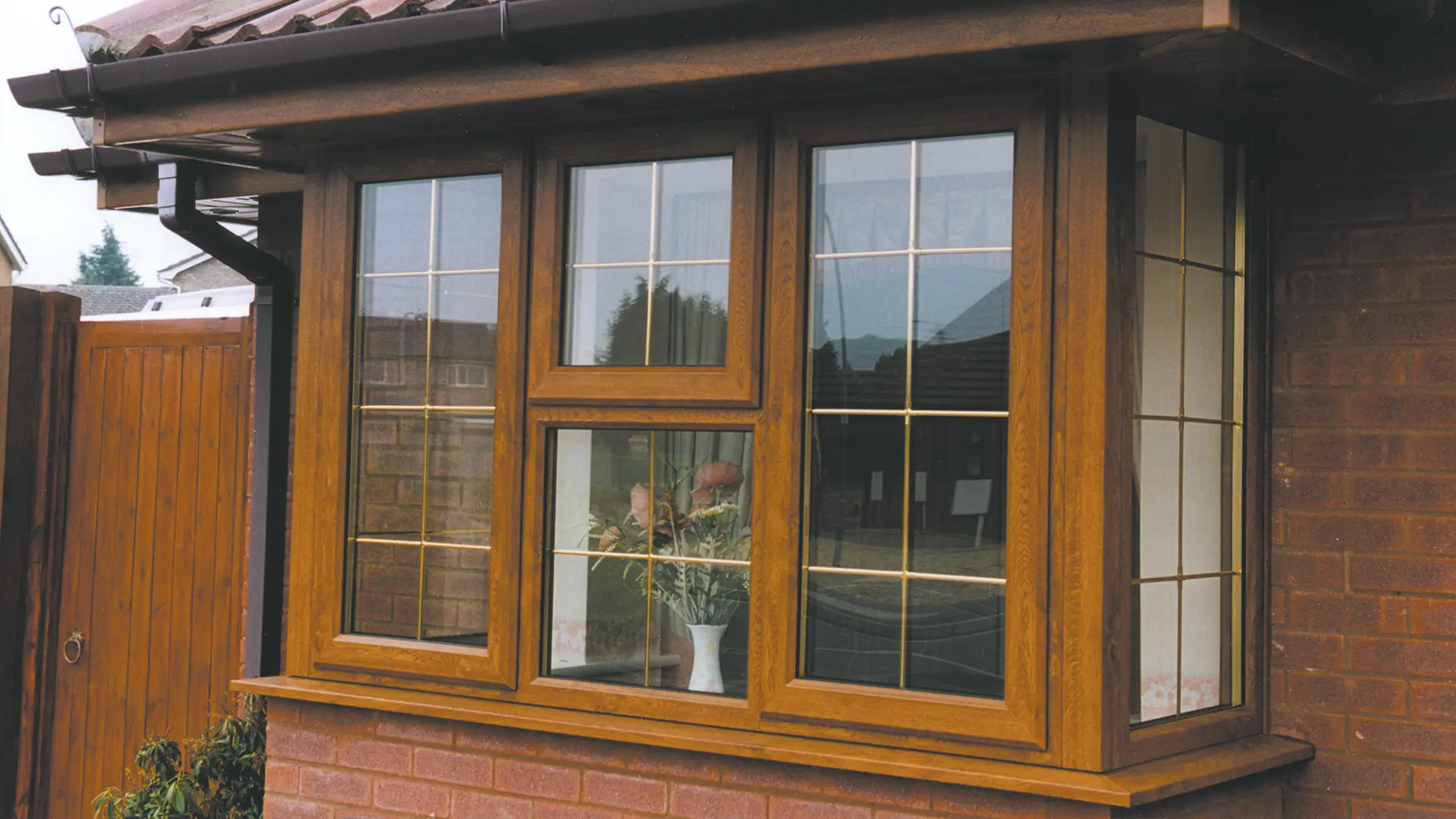 bay-and-bow-windows-outside-looking-at-a-woodgrain-finish-window-fitted-by-newglaze-windows-doors-conservatories-in-bedfordshire